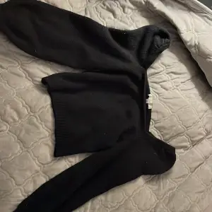 En svart stickad offshoulder tröja i storleken XS