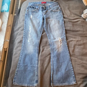 Lågmidjade jeans  - As snygga lågmidjade jeans med slitningar som tyvärr var något för korta på mig. Innerbenslängden är 79cm och midjemåttet 74cm🫶🏼Om flera är intresserade blir det budgivning!