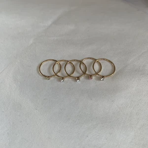 små dainty guldringar med stenar! - dainty, petite guldringar! jag har rättså stora fingrar så de passar bara på lillfingret på mig! alla har en vit/silveig sten förutom ring 4 som har en rosa! en för 5 eller alla för 15 <3  skick: 10/10