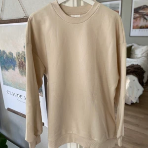 Sweatshirt beige - En helt ny beige sweatshirt från GinaTricot i storlek M.