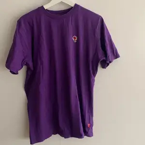 En lila caliroots t-shirt i nästintill oanvänt skick
