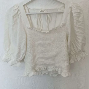 Vit sommartopp - Vit ribbad topp med puffärmar och snöre baktill från H&M i storlek xs, passar även s. Supersöt men är för stor tyvärr.