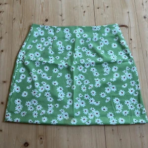Grön kjol med vita blommor - Jag säljer denna gulliga gröna kjol med vita blommor på. Den är jätte söt men säljs på grund av brist av användning. Den är från SHEIN och är i storlek s. Kjolen kostar 50 kr + frakt och ordinarie priset är 100 kr.