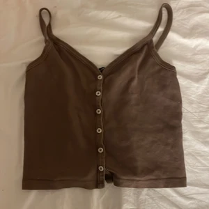 Brun tröja - Säjer nu ett brunt linne med knapar.