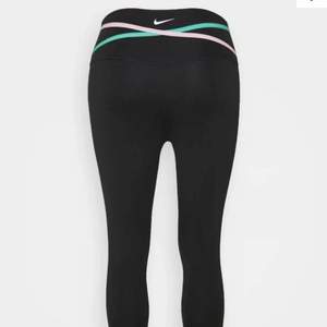 Svarta träningstights från Nike med detalj med färgerna grön och rosa. Använda ca 3 gånger. Ny pris 650.