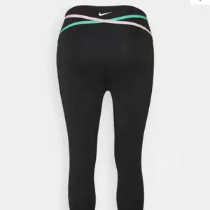 Svarta träningstights från Nike med detalj med färgerna grön och rosa. Använda ca 3 gånger. Ny pris 650.