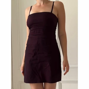 Klänning - Supersöt klänning i ett mörkrött ”skimrande” tyg. Sitter åt super fint och är stretchigt. I bra skick då det finns mindre slitningar på klänningen, vid dragkedjan har sömmen gott upp och det finns några små fläckar som syns i vissa ljus.