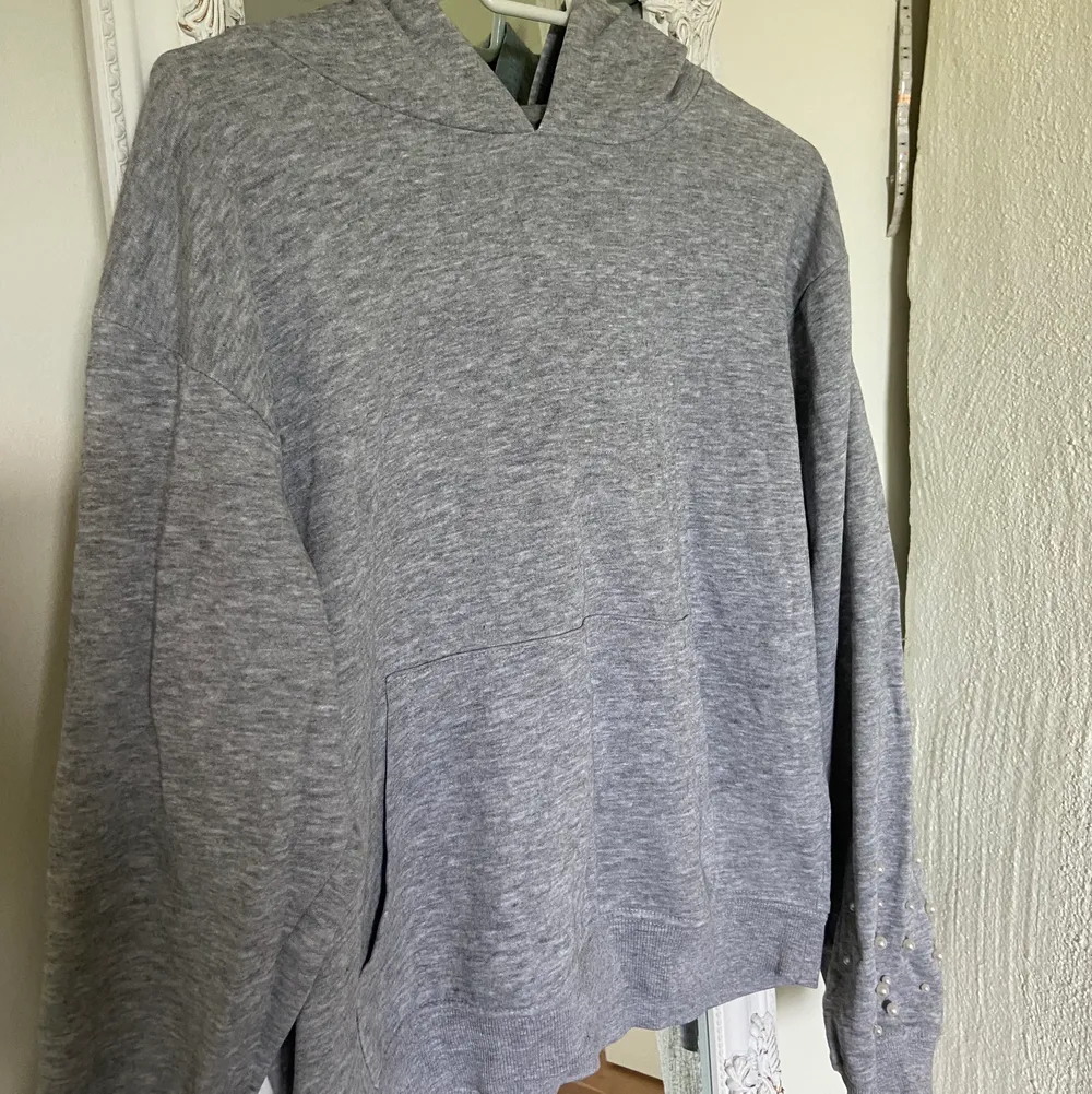 En jättefin grå hoodie i nogot croppad modell med vita pärlor på armarna. Nytt skick. . Tröjor & Koftor.