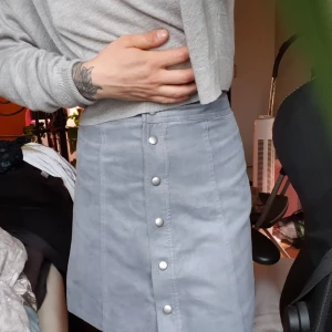 Kjol - En jättesöta kjol från HM. Storlek 34. Sitter tight kring midjan. Går att öppna upp hela vägen med knapparna. Den är ljusblå/ljus marinblått. Är ett annorlunda stramt tyg.