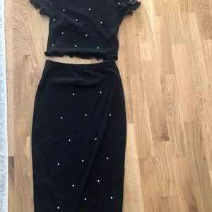 Co-ord - Knälång svart kjol med vita pärlor och en tillhörande topp till kjolen i storlek xs.