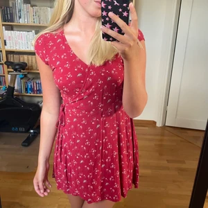 Sommarklänning  - Somrig klänning som knyts omlott. Stängs med en dragkedja i midjan och har en hake vid bröstet. Klänningen är lite för kort för mig som är 172 cm. Från Hollister