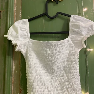 Vit topp - Denna vita top är använd 1 gång. Den ser lika fin ut som när den var köpt och passar storleken xs och s. Säljs för att den inte är till användning längre. Skriv gärna ifall ni har frågor eller är intresserade.