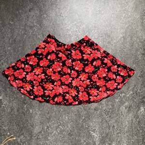 En söt rödblommig kort kjol som är perfekt till sommaren i storlek 34. Använd men i bra skick. Frakt tillkommer.
