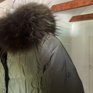 Rockandblue jacka stl 38 - Mörk grön vinterjacka med väldigt stor och fluffig päls. Går precis över rumpan på mig, är 175 cm. Jackan är i nyskick andvänd fåtal gånger! 