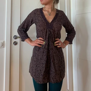 Vinröd/brun-mönstrad klänning/tunika  - Söt sommarklänning/tunika. Funkar över bikini (inte för kort för mig som är 164ish) men också snyggt över byxor. Lila broderi framtill. Inga defekter🎀