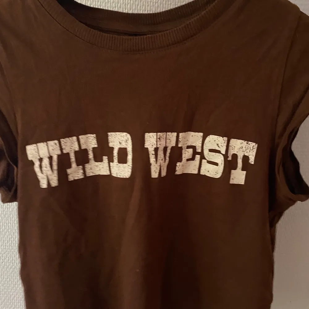 En kort trikåtopp storlek XS från H&M med ”WILD WEST” skrivet mitt på framsidan (det är meningen att texten ska vara fläckig). Köpte förra sommaren och har varit använd 3 gånger sen dess. Originalpriset är 50kr men det kan diskuteras och inklusive frakten💕 . Toppar.