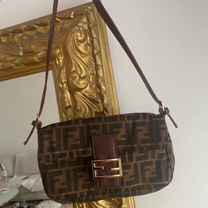Fendi baguette - Jättefin Fendi baguetteväska. Väldigt sparsamt använd så i toppskick 👌 medföljer även en längre rem om man vill ha den som crossbody. inte äkta. OBS! JAG KOMMER RESA BORT 25/5 OCH DÄREFTER VARA BORTA 4V, ÄR DU INTRESSERAD AV ATT KÖPA BEHÖVER DET SKE INNAN DESS
