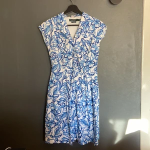 Ralph lauren klänning - Sparsamt använd Ralph Lauren klänning. Klänningen ha fickor samt två band som man kan knyta där bak (eller fram) samt knappen fram och en dragkedja framtid innan knapparna. Det är storlek 4 men skulle säga att det passar en S eller liten M