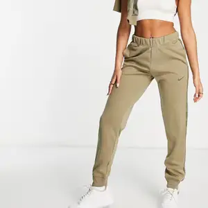 Olivgröna/khaki gröna  Nike mjukisbyxor med tejpad swoosh-logga. Storlek S. Säljes pga glömde göra retur och behöll annan färg. Prislapp finns kvar, endast testade. Frakt diskuteras i dm. 