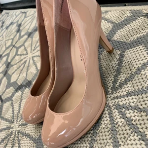 Klackskor i rosa lack strl 36 - Snygga och bekväma klackskor från New Look i storlek 36. Sparsamt använda så de är i bra skick förutom en skada i ena klacken. Finns att hämta i Kvarnholmen (Nacka). Kan även mötas upp centralt 