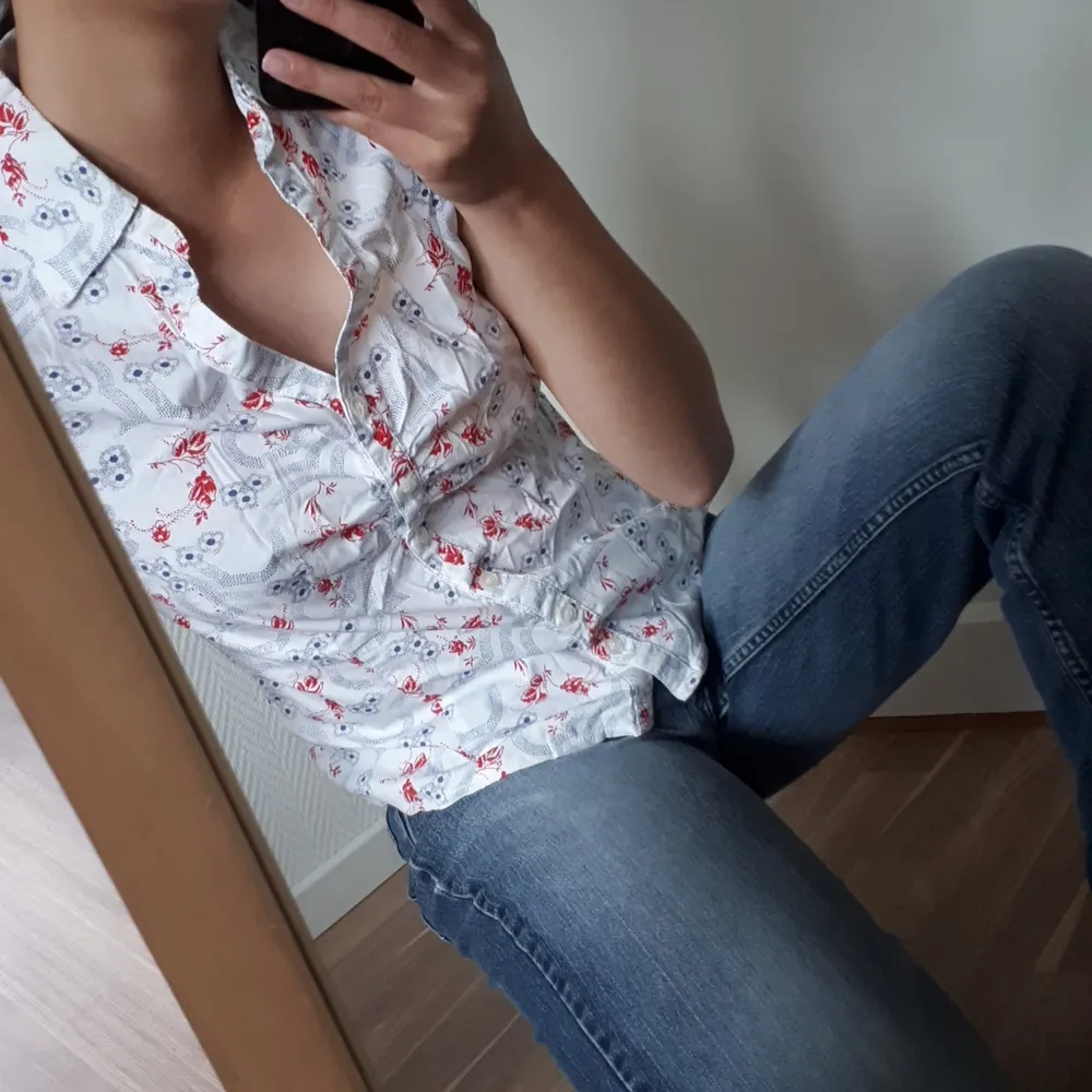 Fin kortärmad skjorta med blå och röda blommor, sparsamt använd 🌺. Toppar.