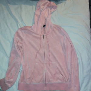 Juicy couture zip up hoodie - Rosa ish peach färgad juicy zip up hoodie. strl:m två hål vid fickorna men inget som syns när man har på sig den. Äkta juicy couture
