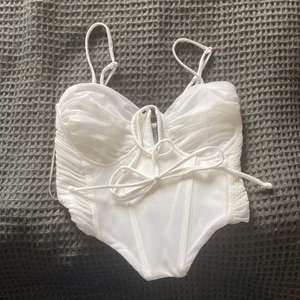 Vit korsett topp  - En helt oanvänd supersöt vit korsett topp från Bershka💞 Säljer pga att den var allelers för liten och lyckas inte göra en retur på den :/ Den är i strl S men skulle själv säga att den är mer  i strl XXS-XS (Bershka har små storlekar).  Slutsåld på Bershka