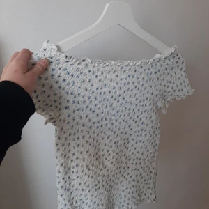Blommig top - Blå blommig top från kappahl, smockat tyg. Off-shoulders. Använd lite men inget tecken på slitage 