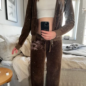 Juicy couture  - Ett JUICY COUTURE set i brun färg, det är vintage ca 1990 och vad jag har sett så kan jag inte hitta någon liknande modell/ tryck. Det är några få sömmar som har gått upp men inga hål i plaggen, om ni vill ha fler bilder så är det bara att säga till!  Jag är ca 167 och både byxorna och koftan sitter perfekt. Jag säljer pågrund av att det inte riktigt är min stil och har inte kommit till användning♻️ Priset nedanför är ink frakt:) Pris kan diskuteras👍