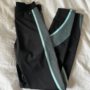 Träningstights strl S - Träningstights ifrån work out i storlek S/36, knappt använda, lite slitning i det blåa mönstret där uppe till höger om fickan där bak. Annars nyskick! Liten ficka med dragkedja ovanför rumpan. Svarta med blåa mönster! Frakt 52kr☺️