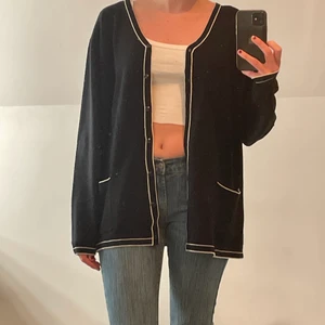 Svart vintage kofta - En svart vintage kofta med vita kanter. Bra skick och väldigt cool❣️ står ingen storlek men skulle säga M, men att den även passar andra storlekar beroende på passform