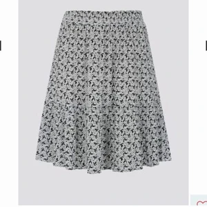 Kjol med blommor - Kjol från Cubus i storlek M. Köpt förra året men bara använd vid två tillfällen, skicket är bra. Svartvit med blommor på. Frakten får köparen stå för