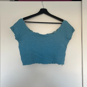 Croppad off the shoulder topp - Blå off the shoulder topp i krinklat tyg. Använd men i bra skick.