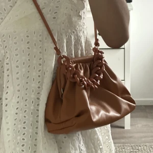 Säljer en söt pouch väska🧡 - Säljer en söt liten pouch väska med kedje-dekor🧡 fåtal gånger använd✨