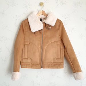 Fodrad biker jacka i mocka - 🌸FÖRST TILL KVARN!🌸 Slutsåld mockajacka, oversized strl XS/S. Känns som en dröm att ha på sig med fluffigtpäls & fluffiga fickor😍 Två spännen vid kragen för ultimat värme💕 Nyskick, testad, då den bara hängt i garderoben sen den köptes. Står xs, men passar även s. Nypris:599kr