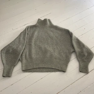 Stickad tröja  - Grön stickad tröja med mudd vid ärmsluten och vid magen samt polokrage.