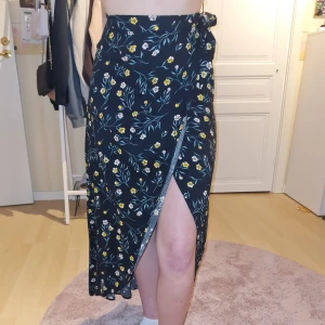 Kjol - Världens somrigaste omlottkjol som går ner till fötterna. Knapp och knytning i sidan. Endast använd fåtal gånger så i nyskick. Säljer eftersom den inte kommer till användning