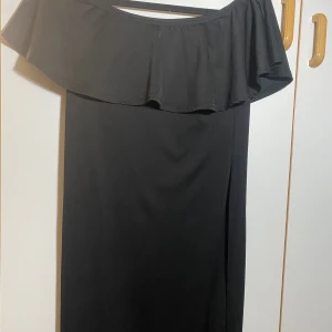 Svart off shoulder klänning - Knappt använd. Svart off shoulder klänning. Kommer till under knäna 