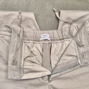 Filippa K byxa beige - En super skön Filippa K byxa som passar både herr och dam, nästan aldrig använda. Stretch i tyget med möjlighet att dra till dom med snöret i midjan!