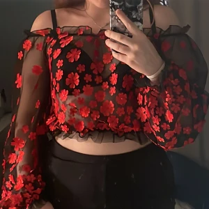 Röd blommig blus - En blommig meshtröja från Fashion Nova. Använd ett fåtal gånger, bra skick! Köparen står för frakten:)