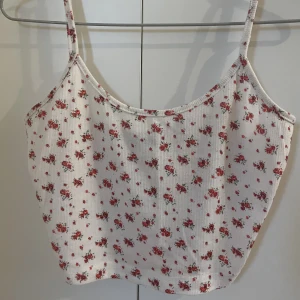 Blommig Topp - Fin topp! Blommig och ribbbad med justerbara band. Frakt tillkommer