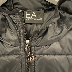 EA7, Emporio Armani dunjacka - Hej, jag säljer en EA7, Emporio Armani dunjacka i storlek S. Köpte jackan för några år sedan till min bror för ca 2000kr, jackan är i nyskick och har aldrig använts. Därför säljer jag den nu för 850kr då den är en gammal modell som har suttit och legat i garderoben. Pris kan diskuteras vid intresse. Det är bara att höra av sig vid intresse:) kan mötas upp i Stocholm eller frakta. 