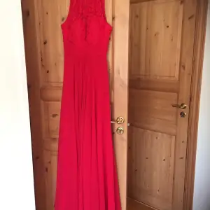 Lilly röd balklänning med blommig spets uptill. Klänningen har inbyggd bh och är bara använd en gång.