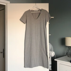 Nakd, grå, XS - Lång grå klänning med slits nedertill på båda sidorna från NAKD, storlek XS. Precis ovan anklarna på mig som är ca 160cm. Endast använd ett fåtal gånger.