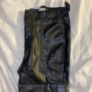 Läder byxor - Fejk läder byxor från pull&bear. Strl 38, litet hål i bak som går lätt att fixa. Fickor på sidan av benen, liknar Cargos. Kan skicka flera foton om det önskas.