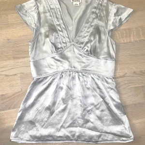 Michael Kors blus - Den sötaste mest drömmiga blus! 🤍☁️🔗 En silver/blå typ stål färgad topp som skulle vara så fin med ett par lågmidjade byxor!! Det står Michael Kors men jag köpte den secondhand så osäker om den är äkta men så fin! Storleken är 4 vilket typ motsvarar 38! 💕 