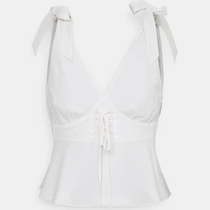 Vit plus - Superfin vit topp i plusmaterial, sitter åt vid midjan och faller ner till höfterna med vackra detaljer. Från Pamela x NA-KD rebourn kollektionen och köpt från zalando. Aldrig använd men prislapp finns ej. Nypris 500kr, frakt tillkommer