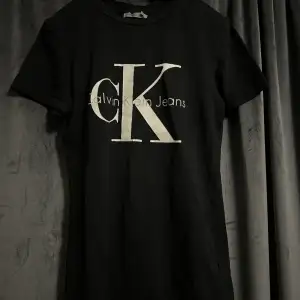 Svart Calvin Klein t-shirt med vit och grå logga. Använd flertal gånger, tyget är i bra skick dock har bokstäverna fått en aning med streck på vissa ställen som syns på bilderna. Storlek XS. Pris kan diskuteras. Köparen står för frakten. Betalning Swish.