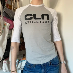 Trekvart babytee grå vit svart y2k cyber - Grå och vit babytee med trekvartslånga ärmar och svart tryck på bröstet och på ärmen 💿💿 Så fin passform och perfekt som  en wardrobe essential! Står XXS men skulle säga att den passar som en XS <3