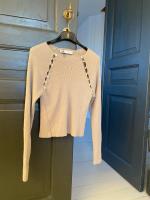 Zara topp - Topp ifrån Zara i storlek M (men väldigt liten i storlek). Toppen går att bära på olika sätt, offshoulder osv.. då det finns knappar du kan knäppa upp. 